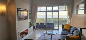 开普敦Beachfront 3-bedroom with Robben Island views的带沙发和壁炉的客厅