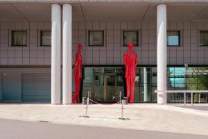 科森扎Ariha Hotel Cosenza的建筑物前的两座红色雕像