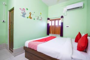 BaharampurOYO Hotel Taj International的卧室配有带红色枕头的白色床