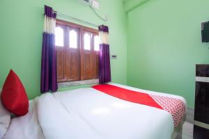 BaharampurOYO Hotel Taj International的窗户客房内的一张床位