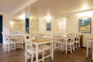 圣让-德吕兹乐莱斯圣雅克酒店的用餐室配有白色的桌子和白色的椅子