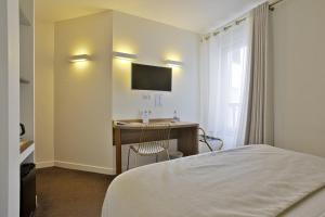 圣让-德吕兹乐莱斯圣雅克酒店的酒店客房配有一张床和一张书桌及一台电视
