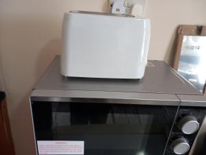 伦敦Lovely 1- Double Bed Studio in London的以及烤箱上带烤面包机的微波炉。