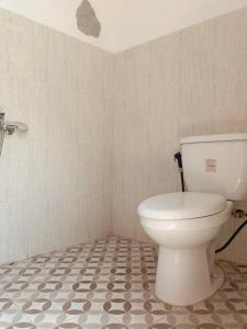 Ngabeand'Topadan Guest House的一间带卫生间的浴室和瓷砖地板。