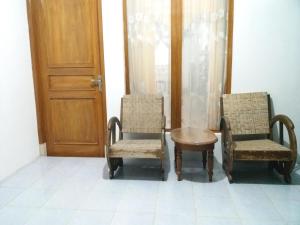 Ngabeand'Topadan Guest House的门旁的两把椅子和一张桌子