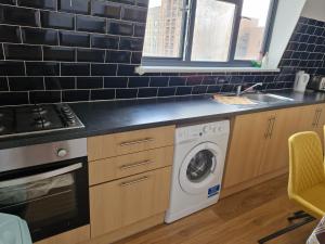 伦敦Immaculate 2-Bed Apartment in London的厨房配有洗衣机和水槽