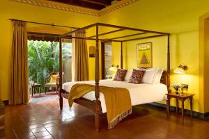 库玛拉孔Taj Kumarakom Resort and Spa Kerala的一间卧室设有天蓬床和庭院。