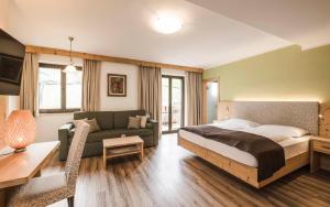 蒂鲁罗卡琳公寓式酒店的一间卧室配有一张床、一张沙发和一张桌子