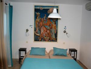 泰晤勒·苏尔·梅尔中庭酒店的卧室配有挂在床上的绘画