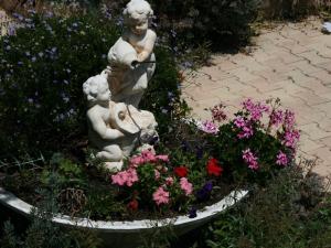 泰晤勒·苏尔·梅尔中庭酒店的鲜花盛开的花园中的雕像