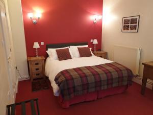 贝里圣埃德蒙兹老炮啤酒厂酒店的一间卧室设有一张红色墙壁的大床