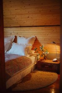 Velykyi KhodakHutsul hygge house的一张带白色枕头的床和一张带台灯的桌子