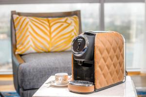 迪拜Golden Sands Boutique Hotel-Dubai Creek的坐在桌子上的烤面包机,喝杯咖啡