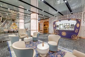 迪拜Golden Sands Boutique Hotel-Dubai Creek的一间带桌椅的餐厅和一间酒吧