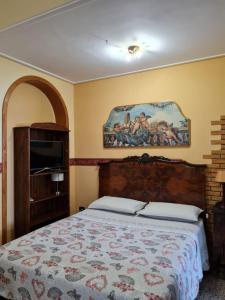 阿沃拉Casa Sanfaso'的卧室配有一张床,墙上挂有绘画作品
