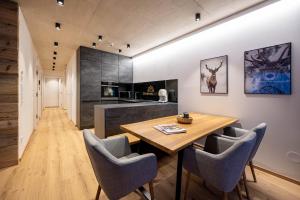 巴德米滕多夫GRIMMINGlofts的厨房以及带木桌和椅子的用餐室。