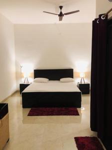瓦拉纳西Tattva Luxurious Apartment的一间卧室配有一张黑色的床和两盏灯。