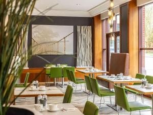布里斯托诺富特布里斯托尔中心酒店的用餐室配有桌子和绿色椅子