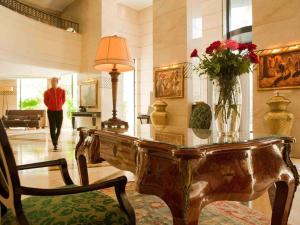 奥兰Royal Hotel Oran - MGallery Hotel Collection的大堂设有一张桌子,上面有花瓶