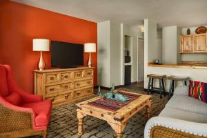 陶斯Hilton Tapestry Collection, Hotel Don Fernando De Taos的客厅配有电视、沙发和茶几