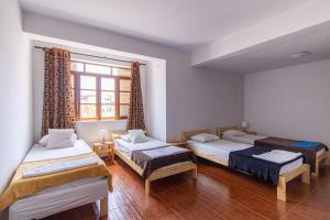 明德卢Maya Apartments的带三张床和窗户的客房