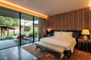 纳仲天Andaz Pattaya Jomtien Beach, a Concept by Hyatt的一间卧室设有一张床和一个游泳池