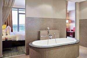 尼尔堡Lindner Hotel Nurburgring Congress, part of JdV by Hyatt的带浴缸的浴室和1间带1张床的卧室