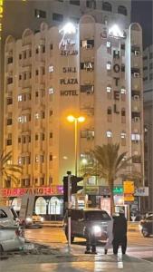 沙迦Sharjah Plaza Hotel的一辆夜间停在酒店前面的卡车