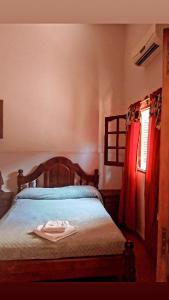 圣米格尔·德·图库玛拉斯卡雷塔斯旅馆的一间卧室配有一张带木制床头板的床和窗户。