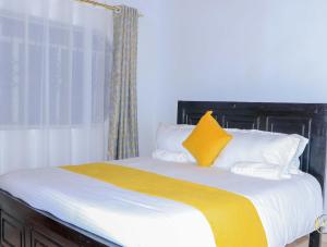 MeruPerfection的一张带黄色毯子和白色枕头的床