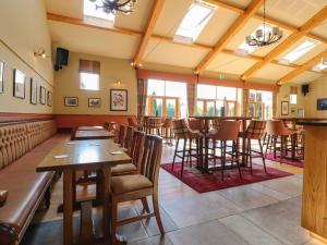 斯基普顿7 The Oaks的餐厅设有木桌、椅子和窗户。