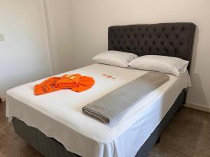 帕劳阿佩巴斯Dantas Hotel的一张大床,上面有橙色毛巾