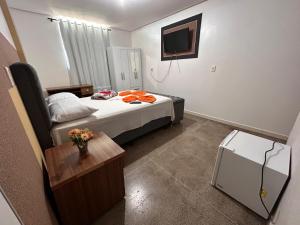 帕劳阿佩巴斯Dantas Hotel的小房间设有床和电视