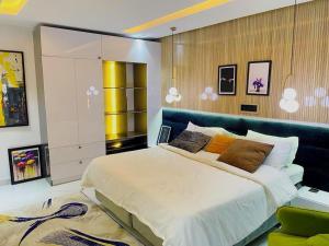 阿布贾Austra Villa Maitama Abuja的一间卧室配有一张大床和蓝色床头板
