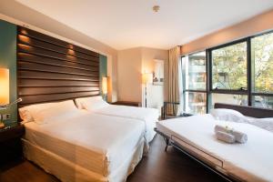 巴塞罗那巴塞罗那佩斯塔纳竞技场酒店的酒店客房设有两张床和窗户。