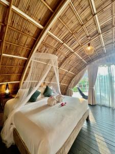 阁遥岛Jaiyen Eco Resort的一张位于带木制天花板的客房内的大床