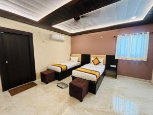 瓦拉纳西Goroomgo Hotel Imperial Varanasi - Wonderfull Stay with Family的客房设有两张床、一张沙发和一个窗口。