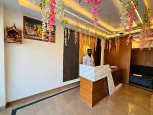瓦拉纳西Goroomgo Hotel Imperial Varanasi - Wonderfull Stay with Family的站在一个花房柜台后面的人
