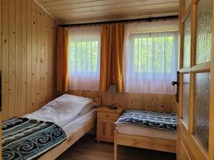 ŚliwiceDomki Zacisze, Okoniny的一间卧室设有两张床和窗户。
