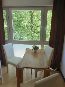 科隆CityPark Aparthotel的一张带白色椅子的木桌和窗户