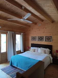 梅利迪什Cabanas de Melides的一间卧室设有一张带木制天花板的大床