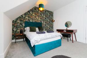 福里斯Carlton Hotel的一间卧室配有蓝色的床和一张书桌