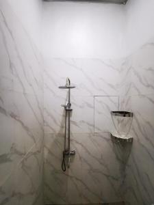 巴东LOBLUS (Low Budget Luxury Stay)的白色大理石浴室,墙上有十字架