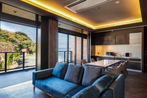白滨FIVE SPRING RESORT THE SHIRAHAMA的客厅配有蓝色的沙发和桌子