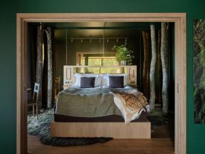 TrensumEriksberg Hotel & Nature Reserve的一间位于绿色客房内的卧室,配有一张大床