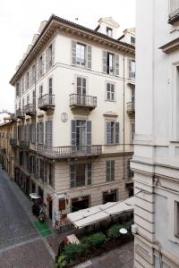 都灵Palazzo Bellezia Luxury Suites的街道上带阳台的大型白色建筑