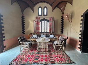 ‘Ezbet Abu ḤabashiThe Desert House, Luxor, Westbank的一间用餐室,在房间内配有桌椅