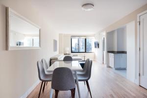 纽约Luxurious 2 BR Apartment with Private Balcony的白色的用餐室配有桌椅