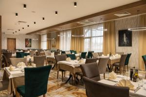 韦林格勒Santé SPA Hotel的用餐室设有桌椅和窗户。