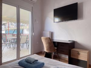 雅典2-bedroom Winter Apartment的一间带一张床和一张书桌的卧室以及一个阳台